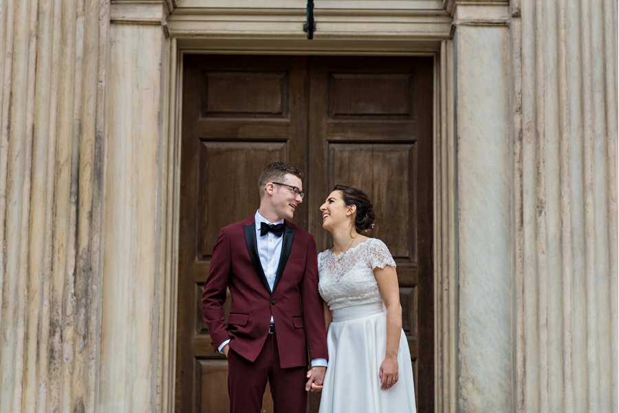 A wedding couple laughing and smiling at each other.